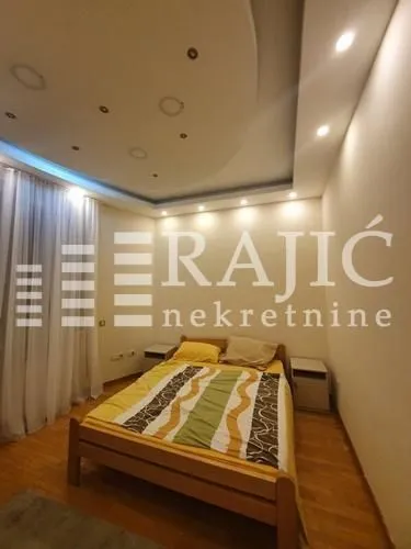 Bedroom with a double bed and a drop ceiling with lighting.