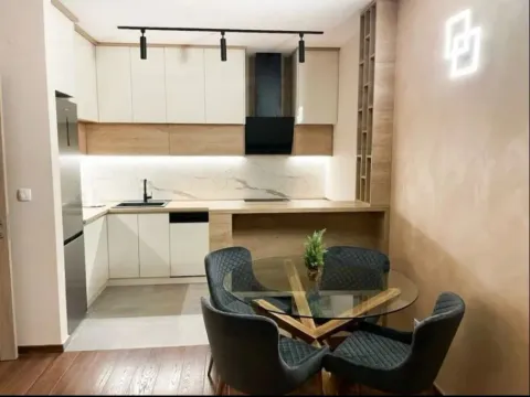 Modern kitchen with a dining area and built-in cabinetry in neutral tones. - image 11