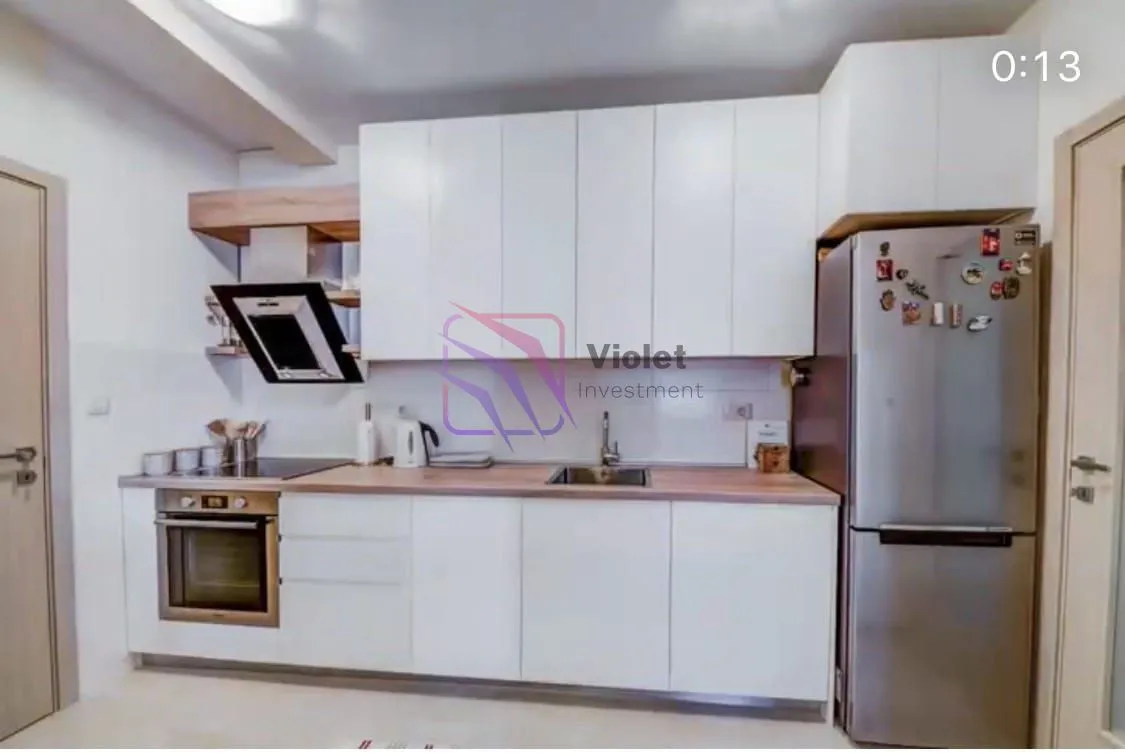 Modern kitchen with white cabinetry and built-in appliances.