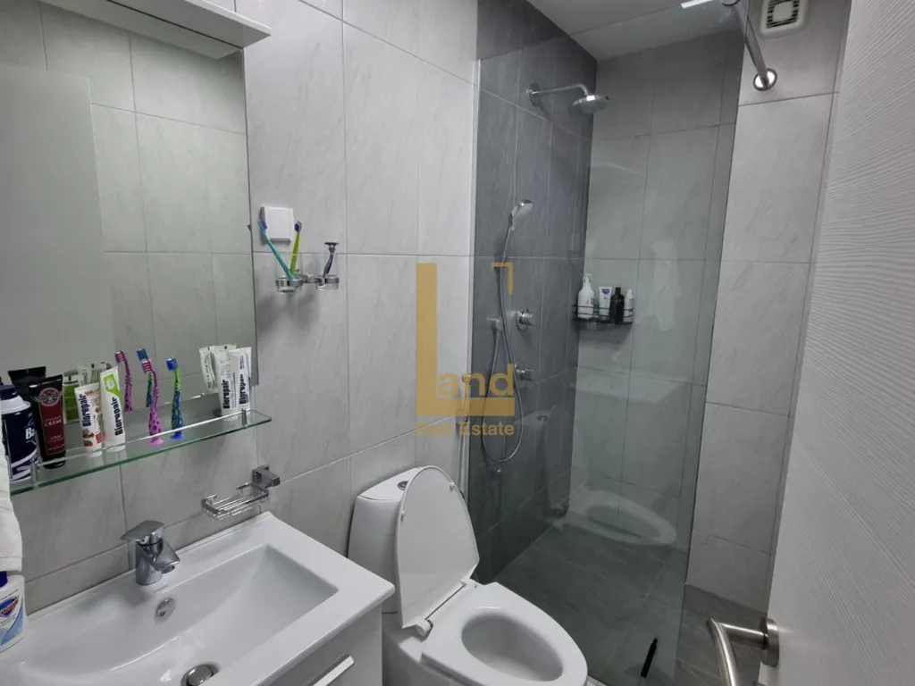 Moderne kupatilo sa tuš kabinom, umivaonikom i WC šoljom.