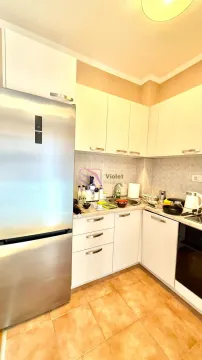 Small kitchen with white cabinetry and a stainless steel refrigerator. - image 2