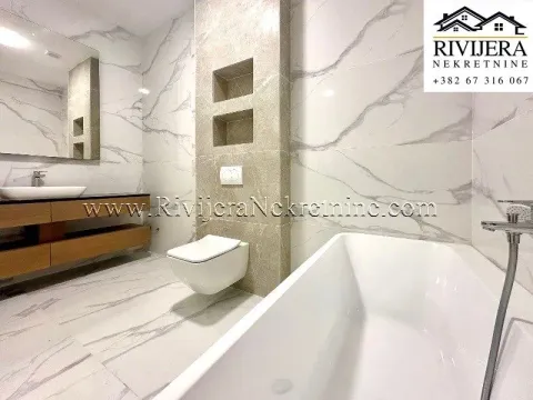 Modern bathroom with a bathtub, wall-mounted toilet, and washbasin. - image 6