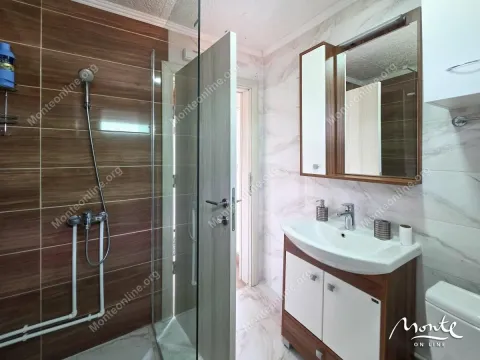 Kupatilo opremljeno tuš kabinom, umivaonikom i ogledalom sa ormarićem. - image 7
