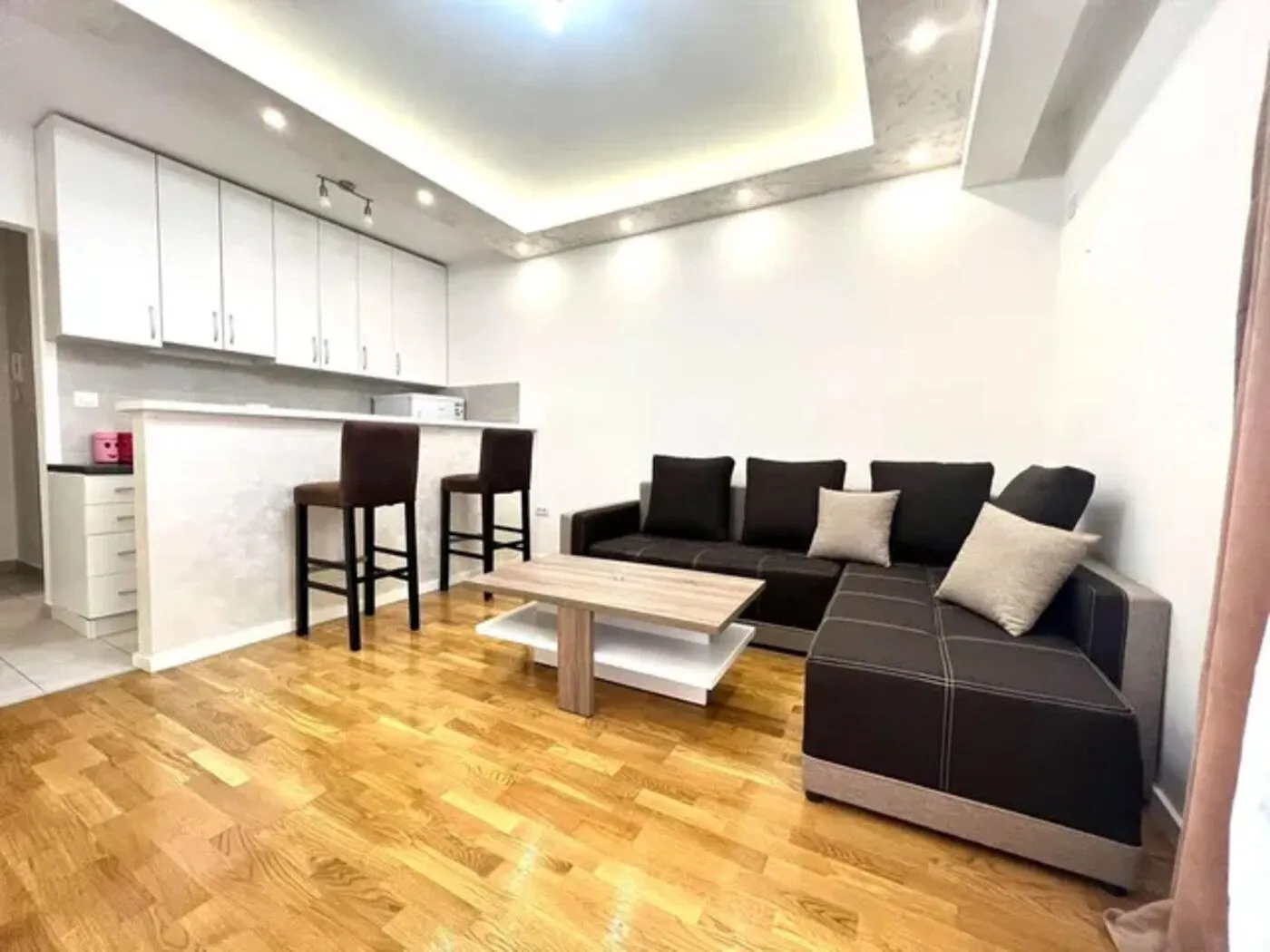 Living room with a sofa set and a dining bar integrated with the kitchen.
