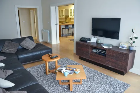 Dnevna soba sa garniturom, TV-om i pogledom na kuhinju. - image 8