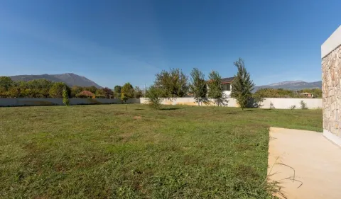 View of the spacious grassy yard and surrounding landscape with mountains. - image 18