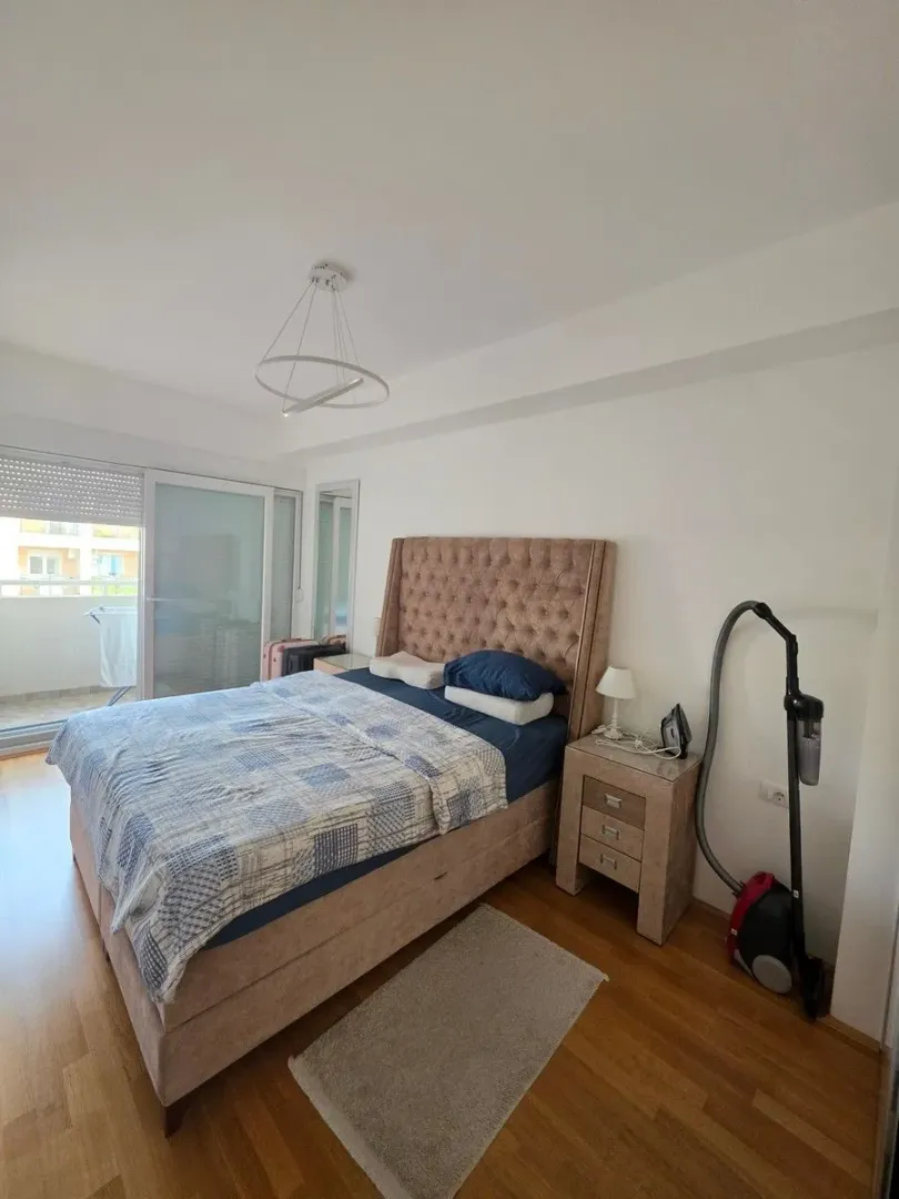 Bedroom with a double bed, bedside table, and access to the terrace.