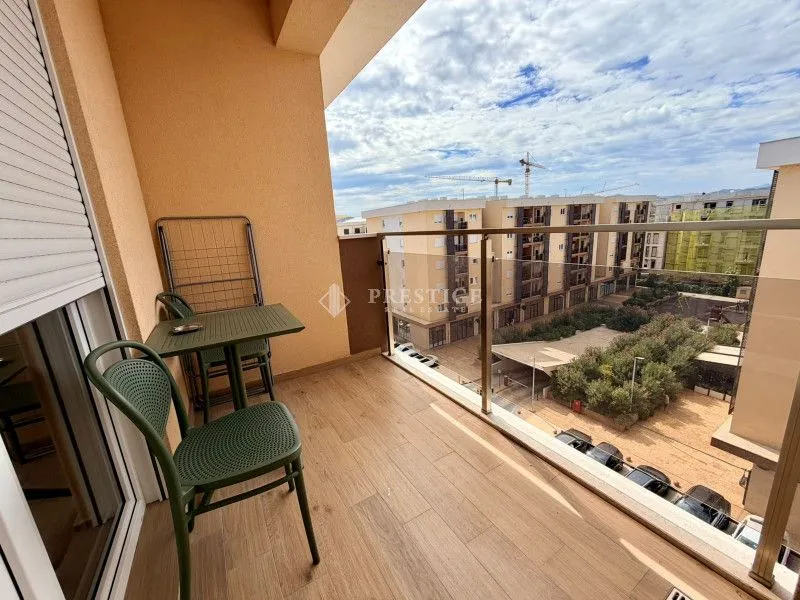 Namješten balkon sa garniturom za sjedenje i pogledom na naselje.