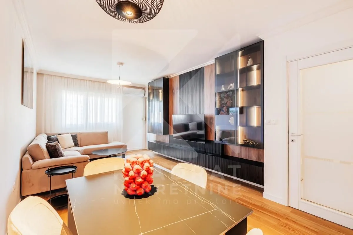 Modern living room with a sofa, dining table, and built-in cabinetry.