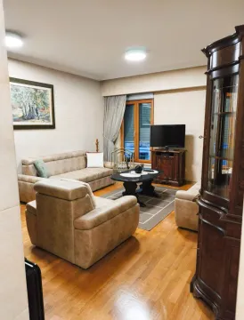 Living room furnished with a sofa set, coffee table, television, and wooden furniture. - image 2