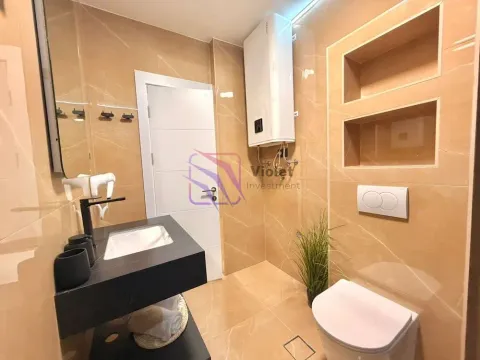 Modern bathroom with a washbasin, toilet, and water heater. - image 22