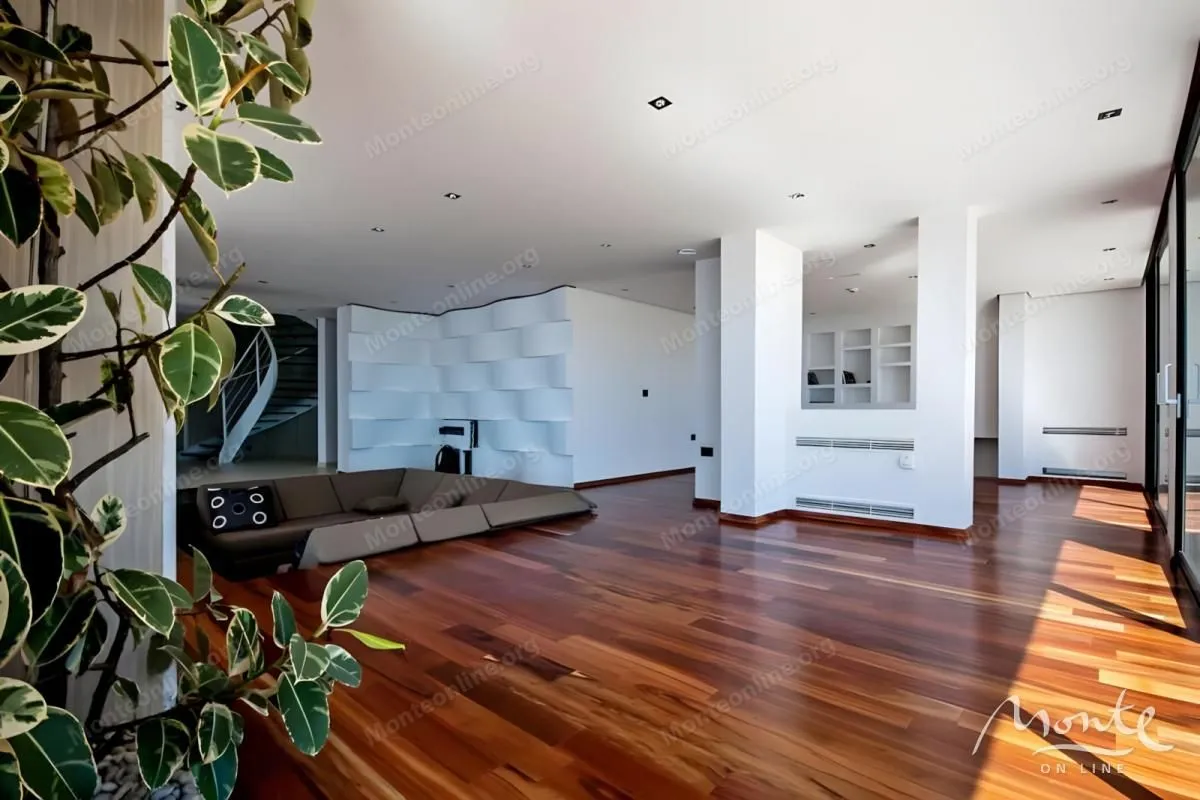 Spacious living room with wooden flooring and a modern sectional sofa.