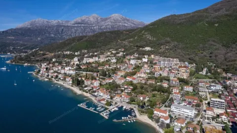 Pogled iz vazduha na priobalno naselje i planine u pozadini. - image 4