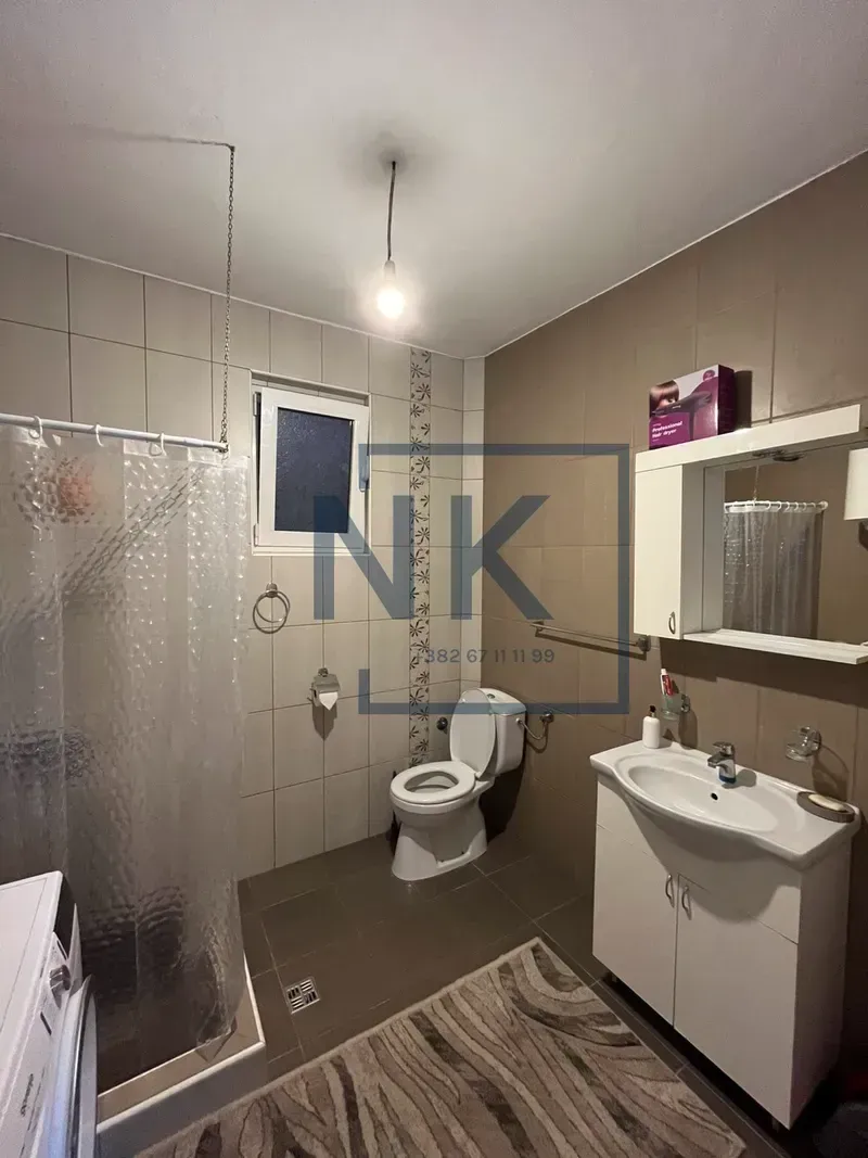Bathroom equipped with a washbasin, toilet, shower cabin, and mirror.