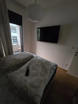 Bedroom with a bed, wall-mounted television, and access to the terrace. - image 5