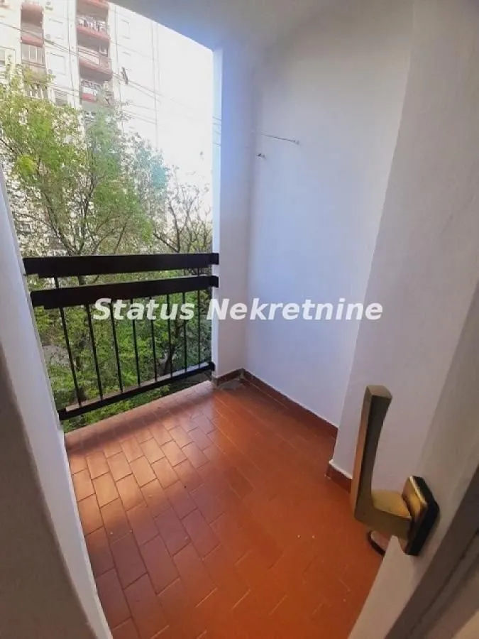 Manji natkriveni balkon sa popločanim podom i pogledom na zelenilo.
