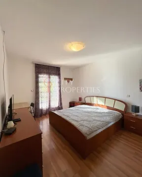 Bedroom with a double bed, wooden furniture, and balcony doors. - image 3