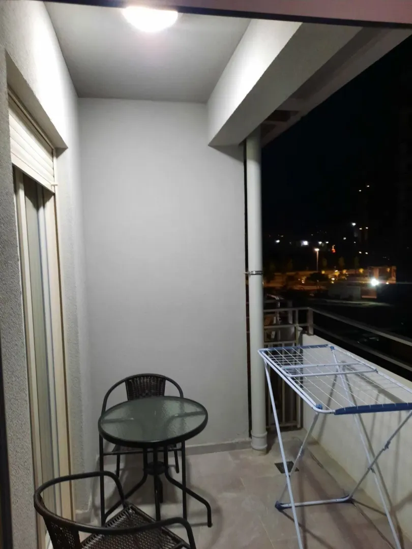 A balcony with outdoor seating at night.