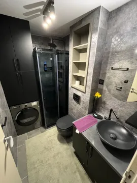 Moderno opremljeno kupatilo sa crnim sanitarijama i tuš kabinom. - image 17