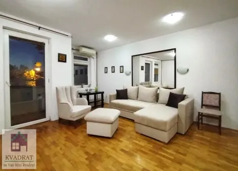 Living room with a sectional sofa, armchair, and footstool on hardwood flooring. - image 3