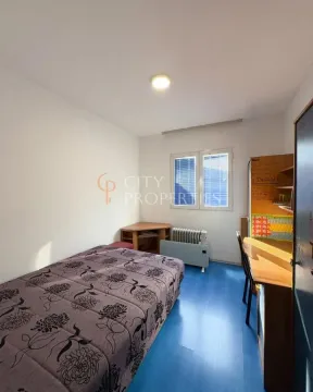 Smaller bedroom with a bed, desk, and a window. - image 4
