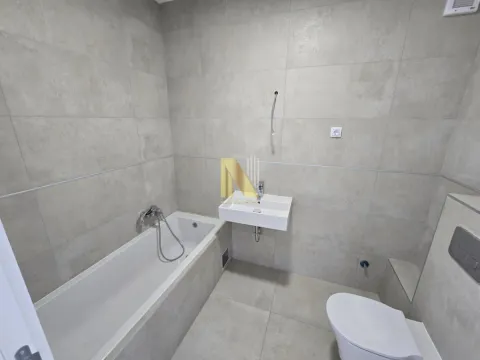 Moderno kupatilo obloženo keramičkim pločicama sa kadom i umivaonikom. - image 11