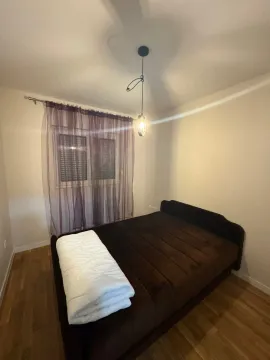 A bedroom with a double bed and a window with purple curtains. - image 9