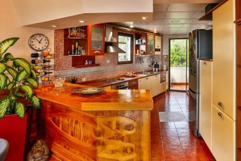 Kitchen with a wooden bar and terrace access. - image 10