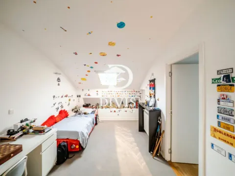 Children's bedroom with a car-shaped bed, a desk, and a roof window. - image 7