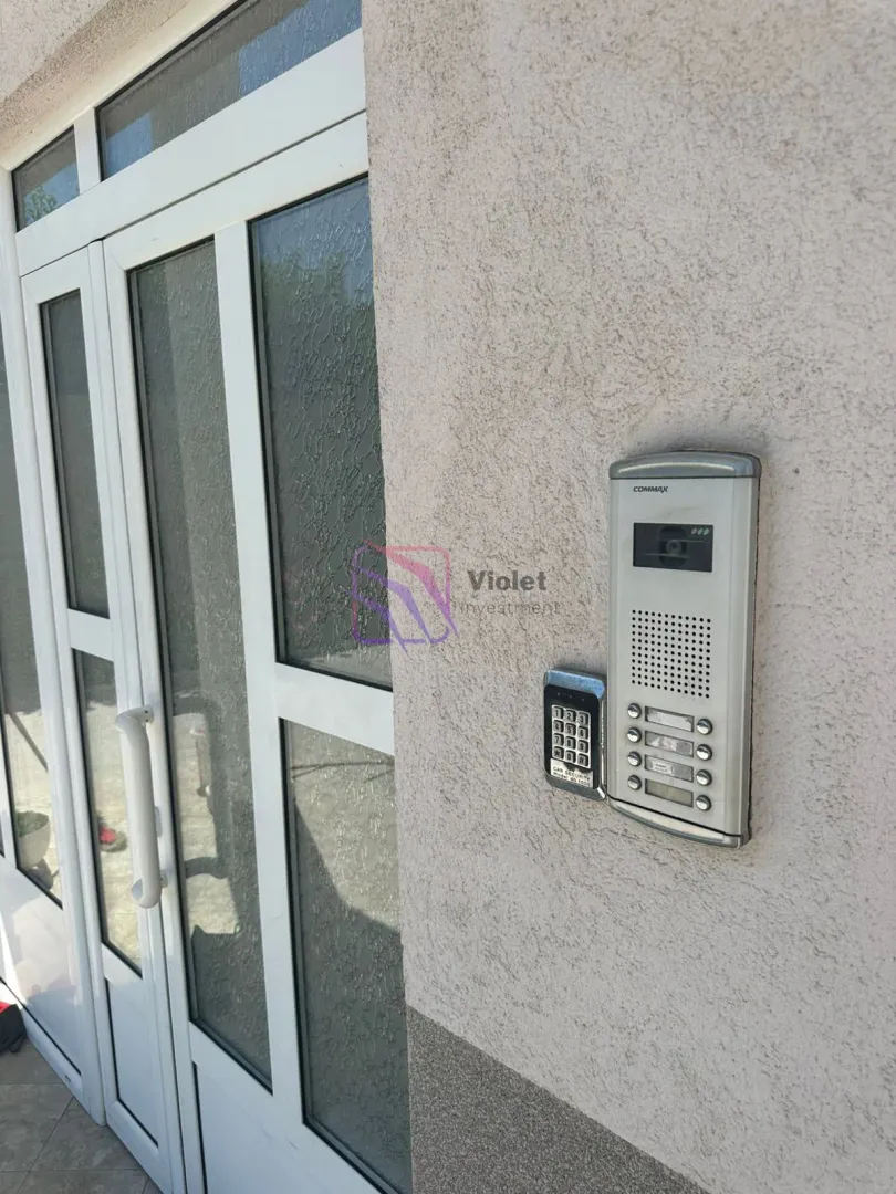 Intercom and keypad for door access installed on the facade next to the building entrance.