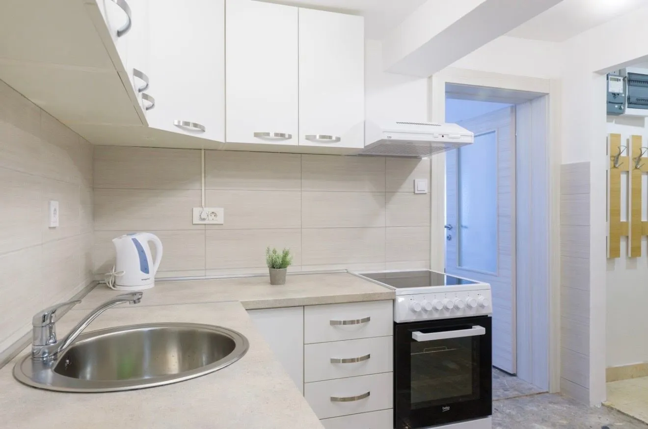 Modern white kitchen with a stove and sink.