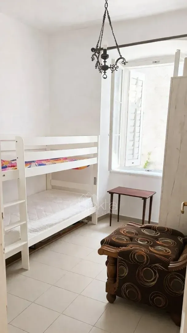 Bedroom with a bunk bed and a window.