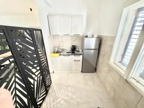 Small kitchen with white cabinets, a refrigerator, and a window. - image 8