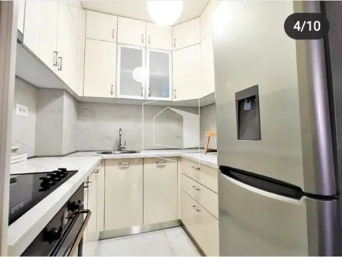 Compact kitchen with light cabinets and built-in appliances. - image 4