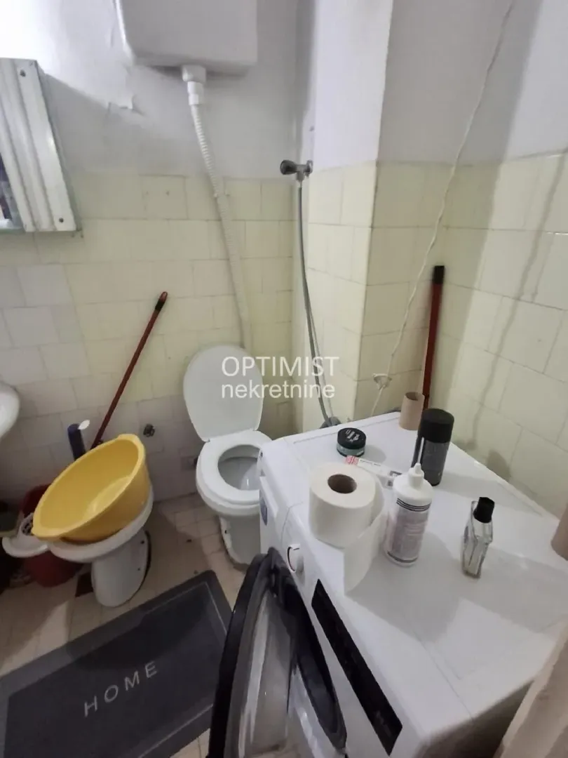 Pogled na kupatilo sa sanitarijama i veš mašinom.