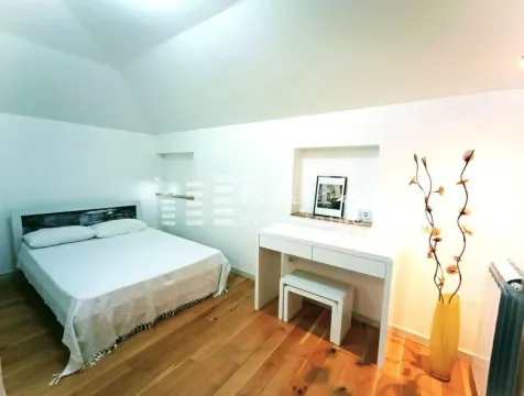 Furnished bedroom with a double bed and wooden flooring. - image 6