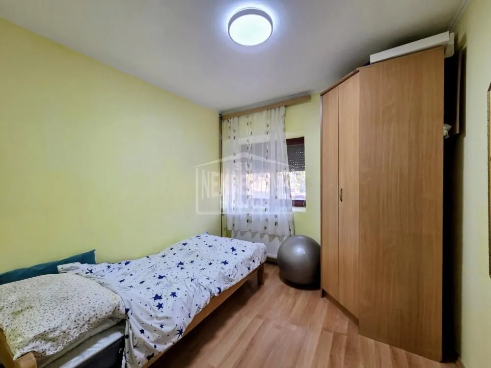 Manja spavaća soba sa krevetom i ormanom.