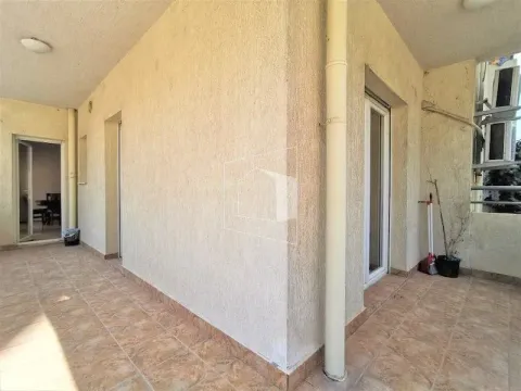 Spacious tiled terrace with a pillar and doors leading to the interior of the apartments. - image 9