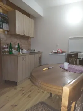 Kitchen with a dining table and wooden cabinets. - image 3