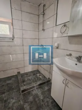 Manje kupatilo sa tuš kabinom obloženom pločicama i umivaonikom. - image 19