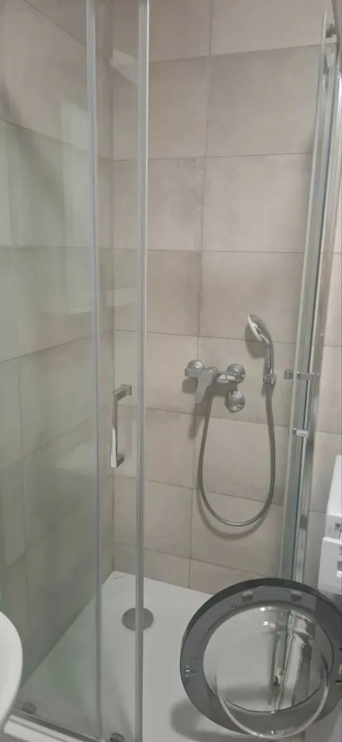 Moderno opremljeno kupatilo sa tuš kabinom.