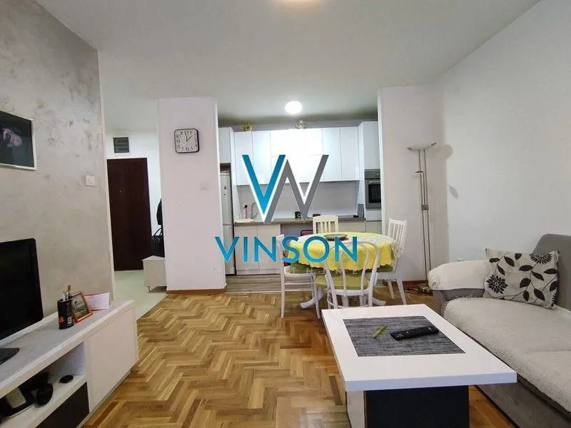Dnevna soba sa trpezarijom i kuhinjom u pozadini.