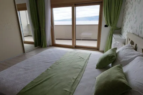 Bright bedroom with a double bed, green accents, and access to a terrace with a sea view. - image 4