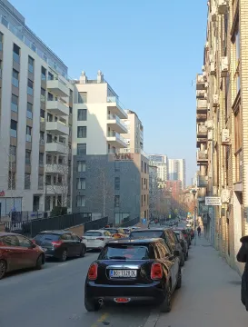 Pogled na ulicu sa parkiranim automobilima i stambenim zgradama. - image 13