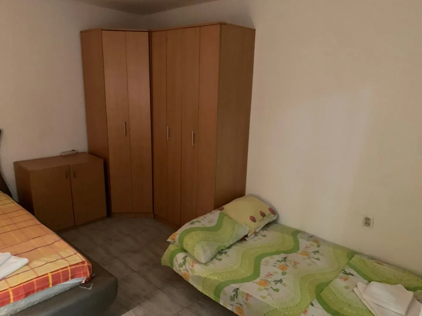 Spavaća soba sa krevetima i drvenim ormarima.