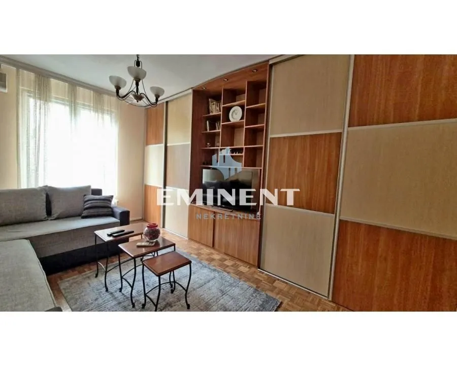 Living room with a sofa and a large built-in closet with TV shelves.