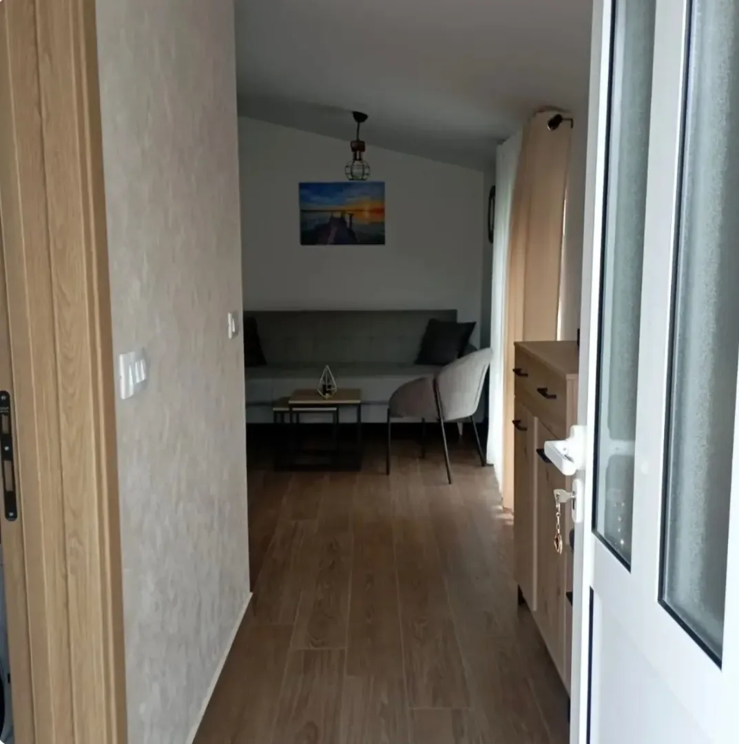 Pogled iz hodnika na dnevni boravak sa garniturom.