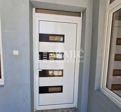 Ulazna vrata kuće sa sivom fasadom. - image 11