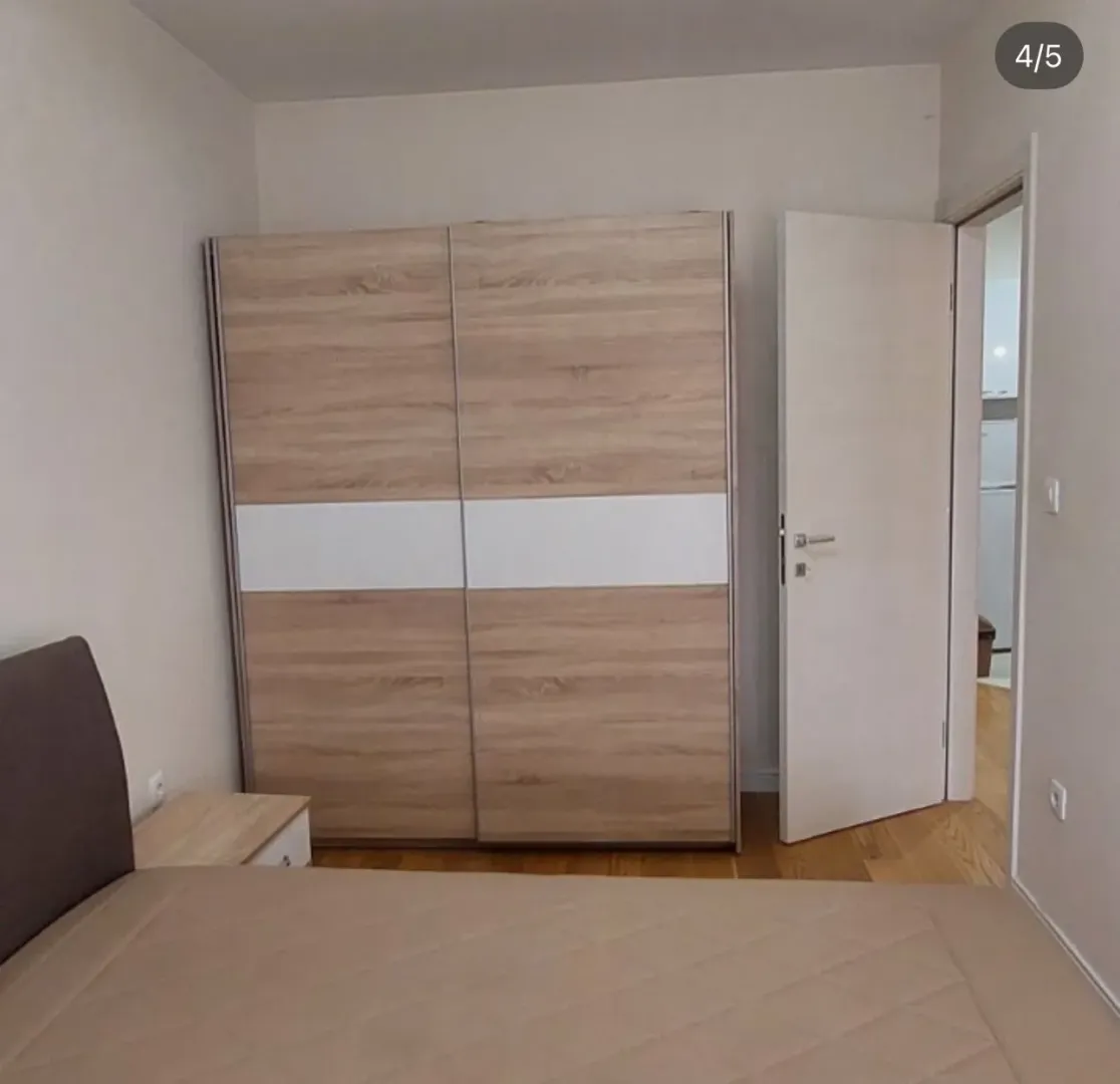 Bedroom with a double bed and a large wooden wardrobe.