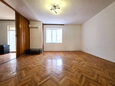 Empty room with hardwood parquet flooring and wooden folding partition doors. - image 3